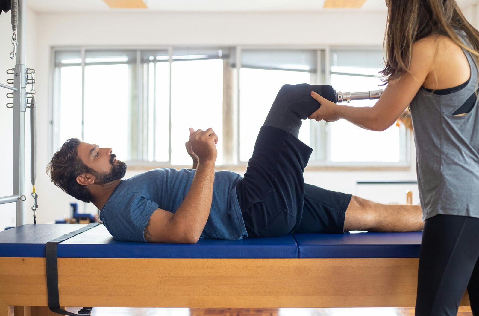 Man and woman engaging in a physical therapy session, focusing on prosthetic leg recovery and rehabilitation.